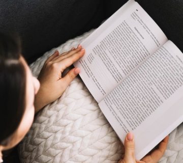 یک تصویر تزئینی مربوط به کتاب تولید محتوا. یک خانم در حال مطالعه کتاب مرتبط با تولید محتوا.